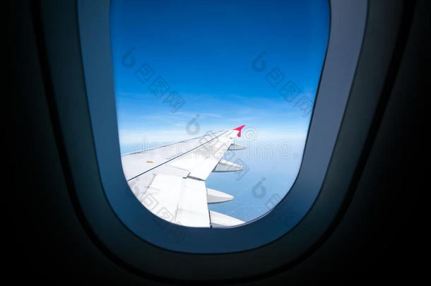 飞机机翼在蓝天上，通过飞机窗口观看，有复制空间