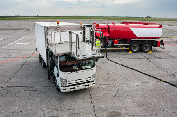 机场停机坪上的餐饮卡车和加油卡车
