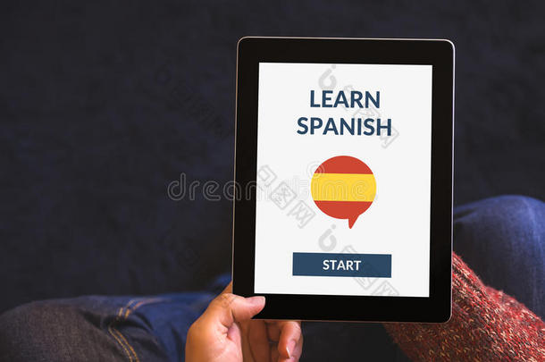 手拿平板电脑与在线学习西班牙语概念在屏幕上