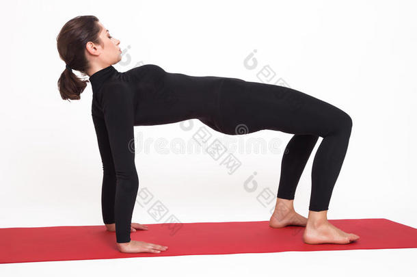 穿着黑色西装做瑜伽的漂亮运动女孩。 普伏塔纳纳·阿萨纳木板姿势。 在白色背景上。