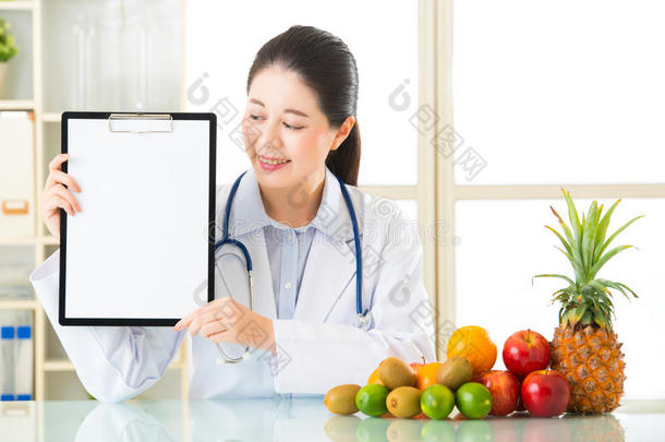 <strong>医生营养师</strong>与水果和持有空白剪贴板