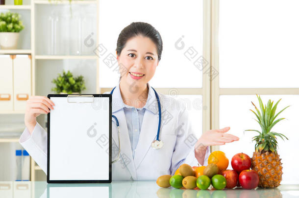 <strong>医生营养师</strong>与水果和持有空白剪贴板