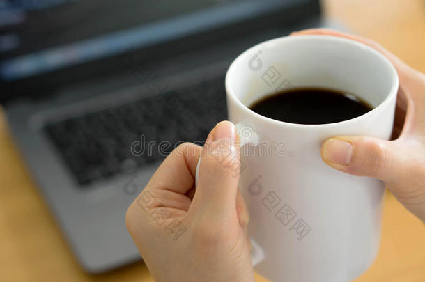 一位使用平板电脑网络书籍和喝咖啡的女商人