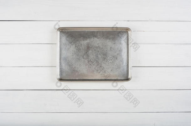 上图的金属饼干板烹饪锅铺设或悬挂在中心的乡村白色或灰色木板背景空白区域