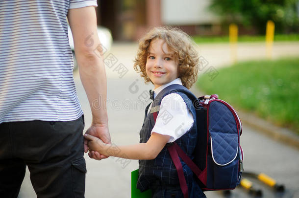 可爱的小一年级学生和爸爸一起上学。