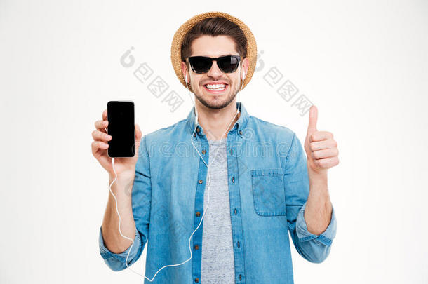 欢快的年轻人戴着耳机，显示着空白的屏幕手机