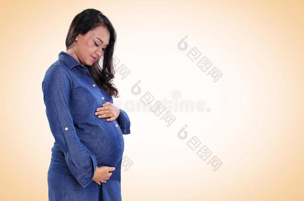 美丽的怀孕妈妈站在复制空间上