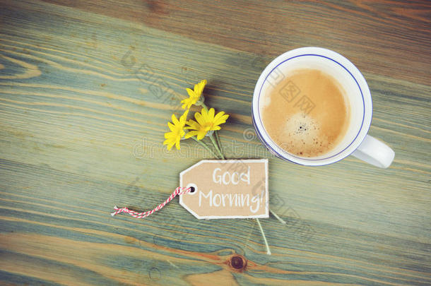 咖啡杯和雏菊花，木<strong>桌</strong>上有愿望纸板标<strong>签</strong>。 早上好浪漫的信息。