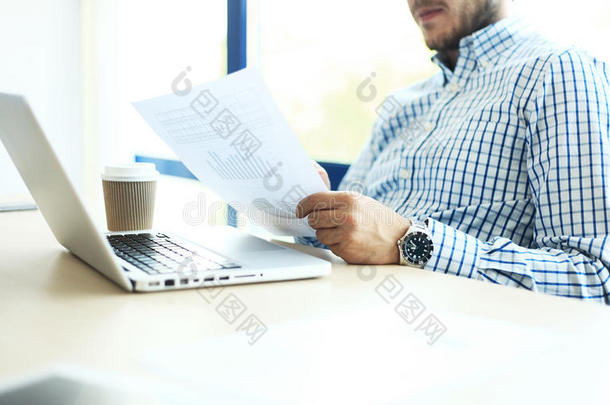 商务人员在办公室工作，桌上有笔记本电脑和文件