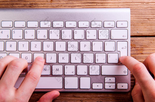 无法辨认的人在电脑键盘上写字的手。