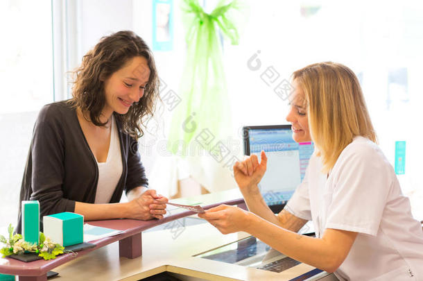 美容师女人在纸上向顾客展示价格