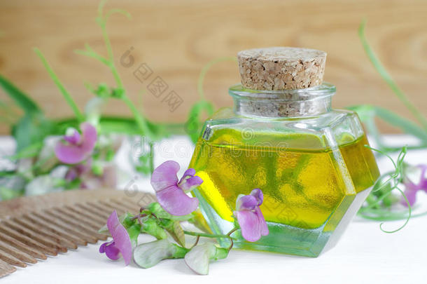 瓶化妆品油与花提取物和木制梳子，用于天然头发护理