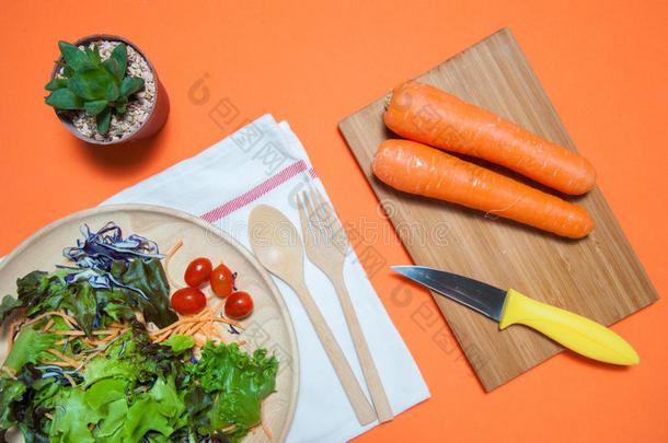 新鲜沙拉与水果和蔬菜在橙色背景的顶部视图。 健康的食物，吃干净的概念。 平躺。