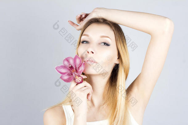 美丽的女人，粉红色的花，她的手举起。 打蜡腋窝。 脱毛结果。