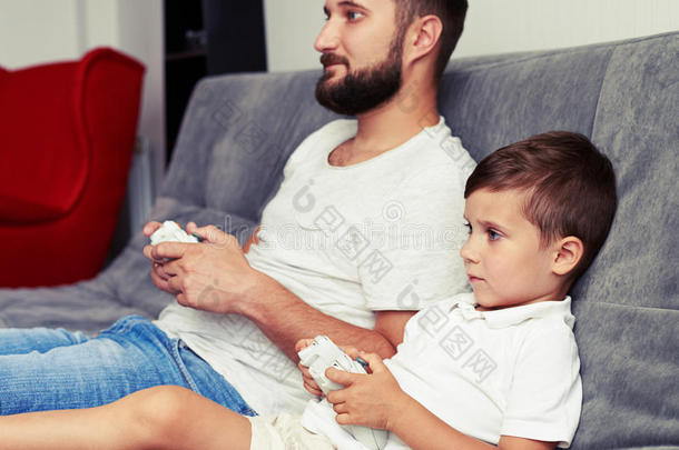 父亲和儿子集中精力玩游戏使用操纵杆