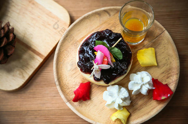 木制盘子上的蓝莓芝士蛋糕，咖啡店或餐厅里的咖啡蛋糕，木制果酱蓝莓蛋糕