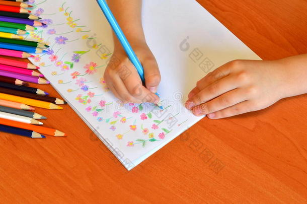 孩子手里拿着一支铅笔，用花画了一片草地。 一套铅笔。 儿童艺术。 <strong>幼儿园</strong>绘画课