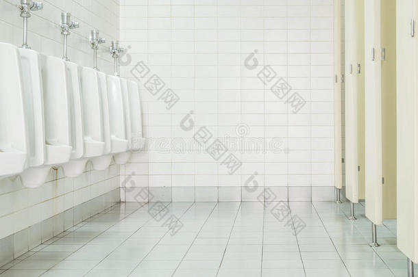 特写瓷砖墙在厕所的人与厕所的看法由小便池和小房间，内部在旧厕所的背景