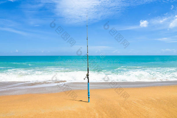 在空旷的海滩上钓鱼竿，有美丽的海洋。 在海滩上，鱼竿在海滩上与鱼钩旋转