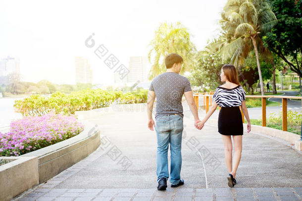 亚洲夫妇牵手在公园里散步