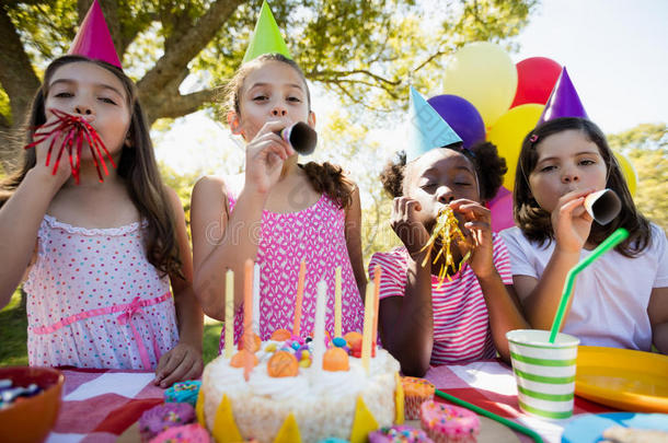 孩子们在生日聚会上吹着生日号角