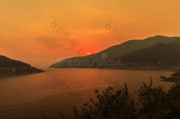 日落时美丽的风景在湖边的山脉上