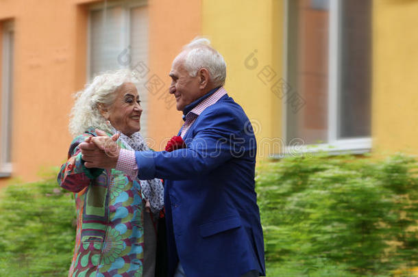 一对老年夫妇在街上跳舞。 在户外跳华尔兹。 真爱。