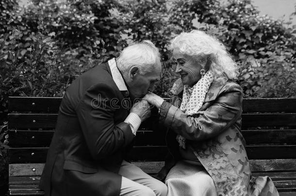 老人亲吻老妇人的手。 黑白相间。
