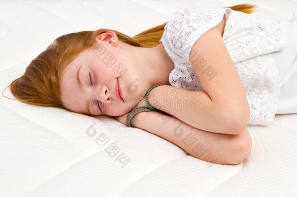 一个年轻的女孩躺在床上。 优质床垫。