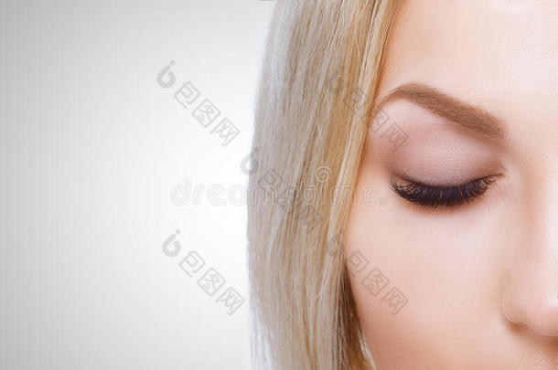 蓝色眼睛的美妆。 美丽的脸特写的一部分。 完美的皮肤，长长的睫毛，化妆的概念。