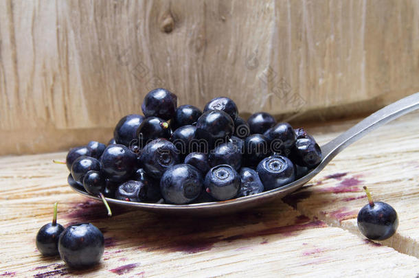 蓝莓。 勺子和木制背景上的蓝莓。