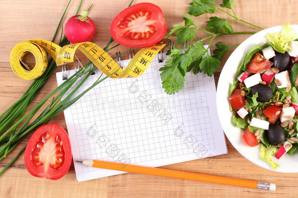 新鲜希腊<strong>沙拉</strong>配蔬菜，厘米和记事本写笔记，健康营养和减肥概念