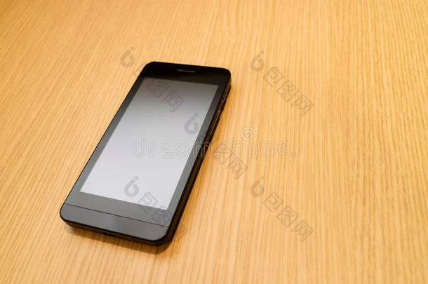 黑色智能手机在木桌背景与复制空间