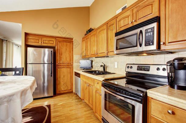 舒适的厨房和餐厅内部与棕色橱柜和不锈钢电器