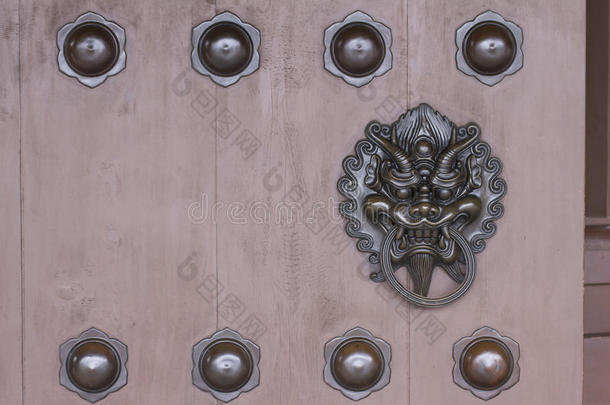 青铜龙头敲钟器装饰在木门上