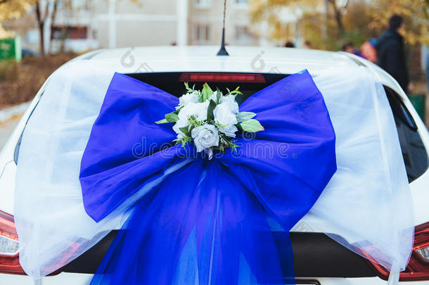 一辆用玫瑰装饰的黑色婚车。 用鲜花和丝带装饰的豪华婚礼车
