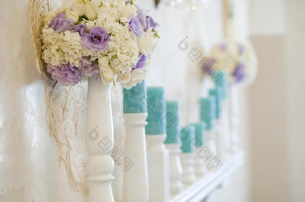 花的排列与白色和蓝色的花和蜡烛上的烛台。 婚礼装饰