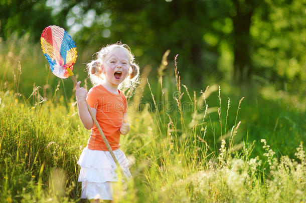 可爱的小女孩用她的独家新闻捕捉蝴蝶和虫子