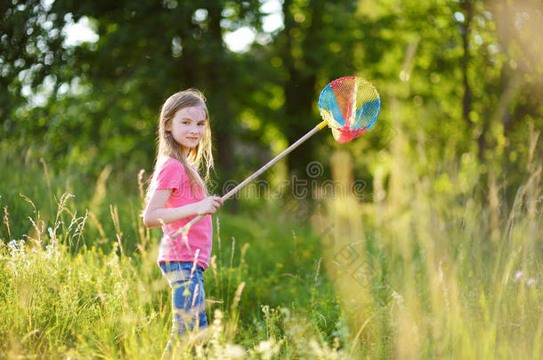 可爱的小女孩用她的独家新闻捕捉蝴蝶和虫子