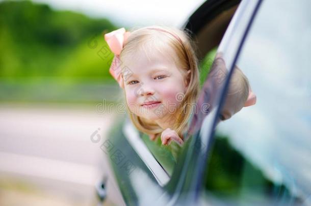 有趣的小女孩把头伸出车窗外