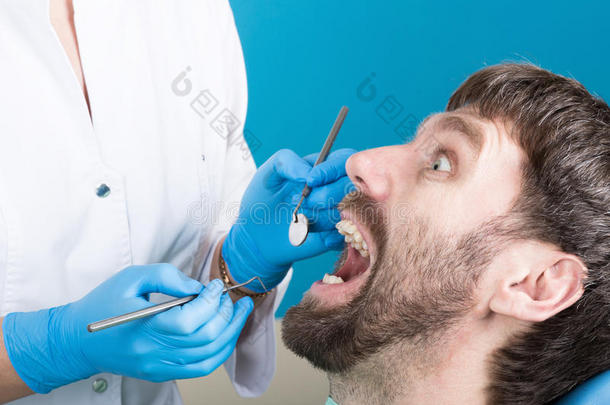 医生检查口腔是否蛀牙。 龋病保护。 蛀牙治疗。 牙医在牙科工作