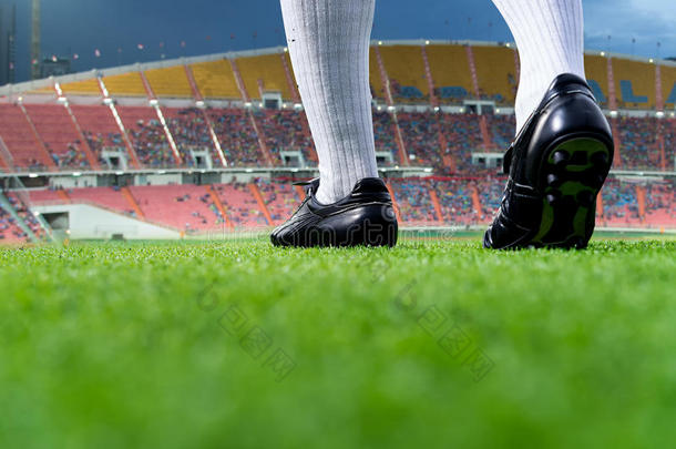 足球运动员或足球运动员的脚在绿草地上行走