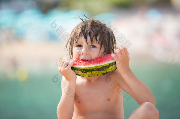 可爱的孩子，男孩，在海滩上吃西瓜