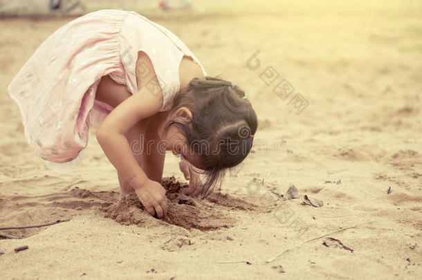 孩子亚洲可爱的小女孩在操场上玩沙子