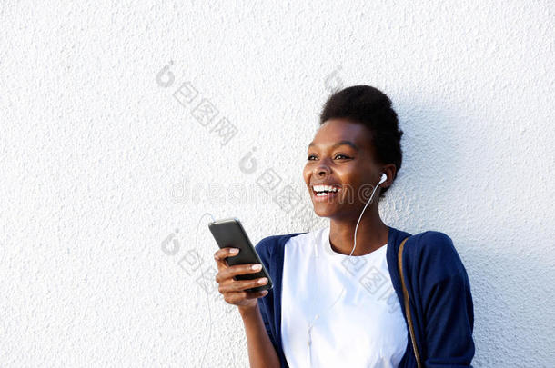 快乐的年轻非洲女人在智能手机上听音乐