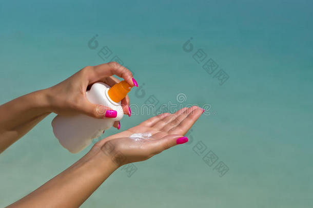 女人的手从防晒霜瓶子里放防晒霜