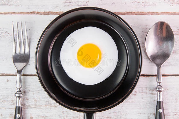 煎蛋在小锅与手柄在白色木板，顶部vi