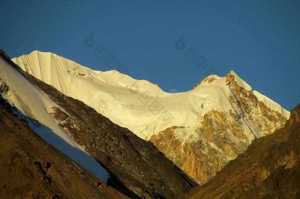 安第斯山脉的雪覆盖着日落之光的山