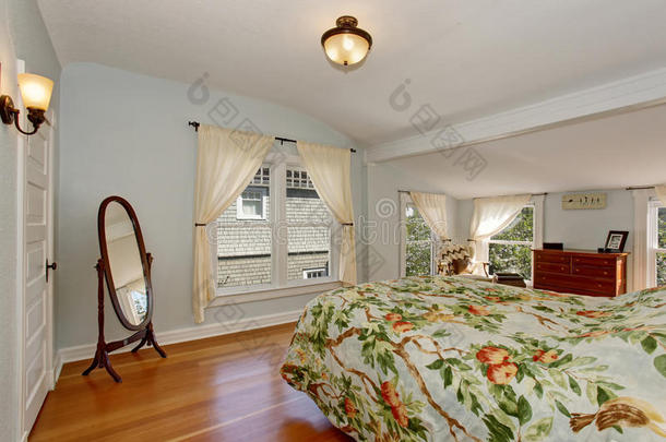 舒适的卧室内部与拱形天花板和硬木地板。