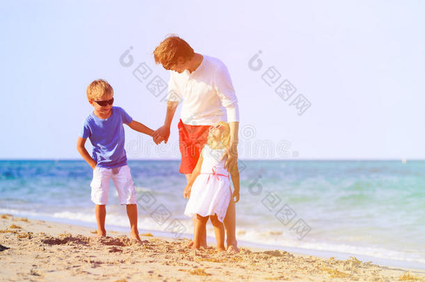 父亲和儿子和女儿在海滩上交谈